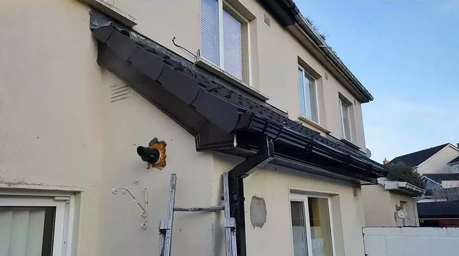 Cast-iron gutter on a period terrace being assessed for rust, joint drips and bracket condition