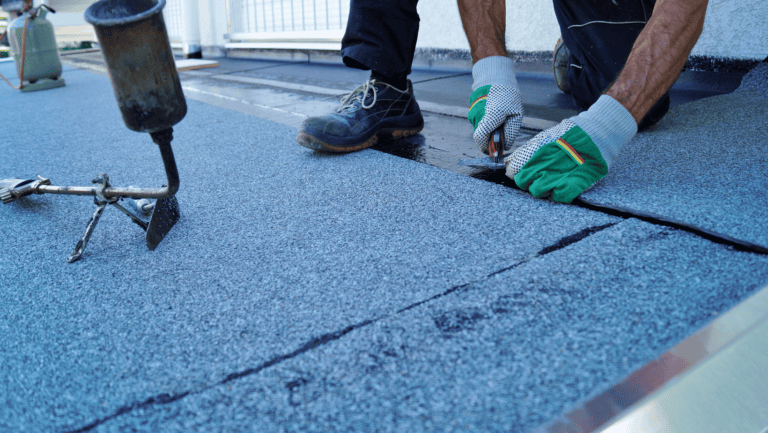 Roofing felt being laid on a stripped roof section, battens exposed, on a Wilton tile roof repair